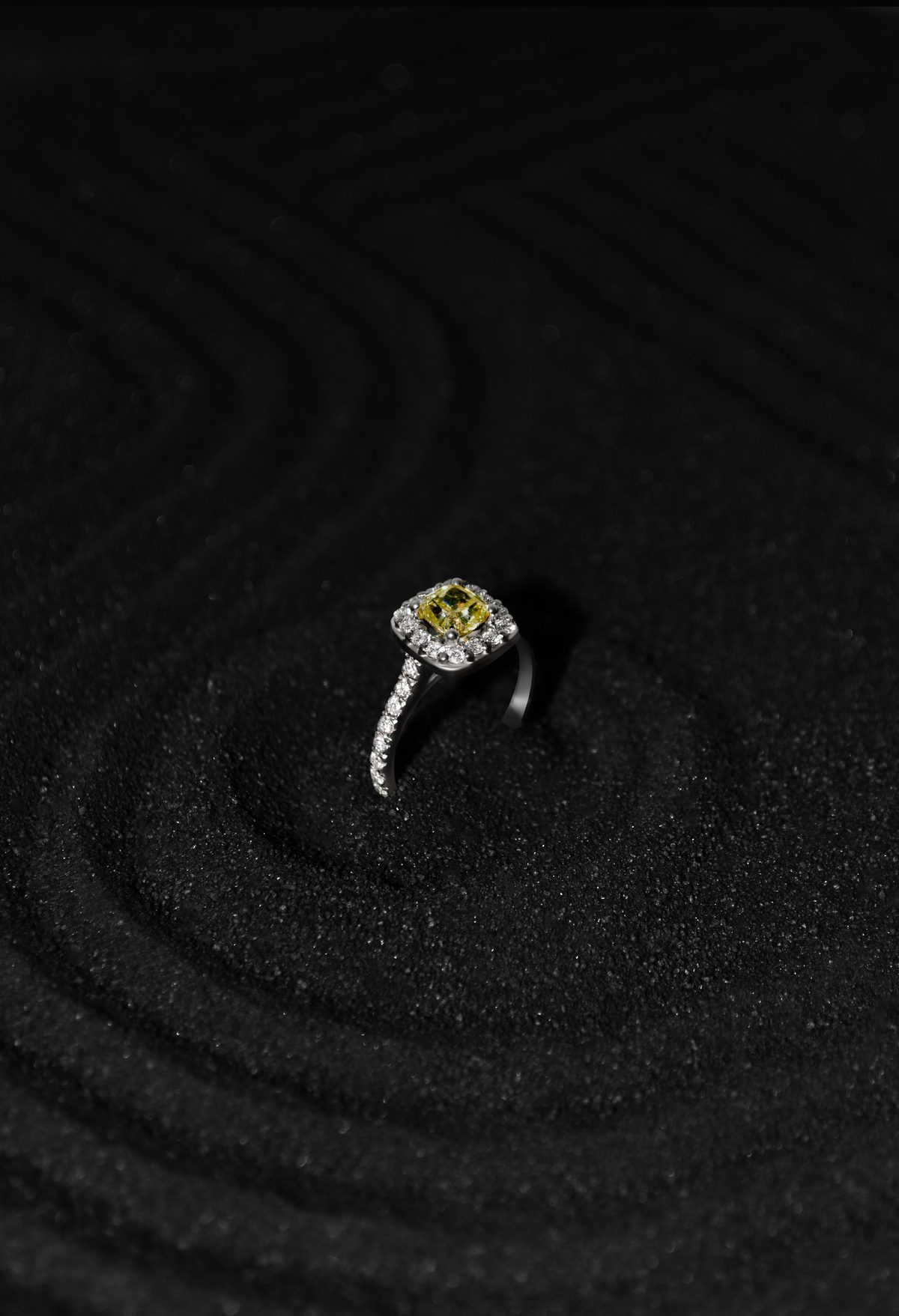 Anillo YS.04 con diamante amarillo de 1 quilate y halo de diamantes blancos en oro blanco 18k, sobre arena negra