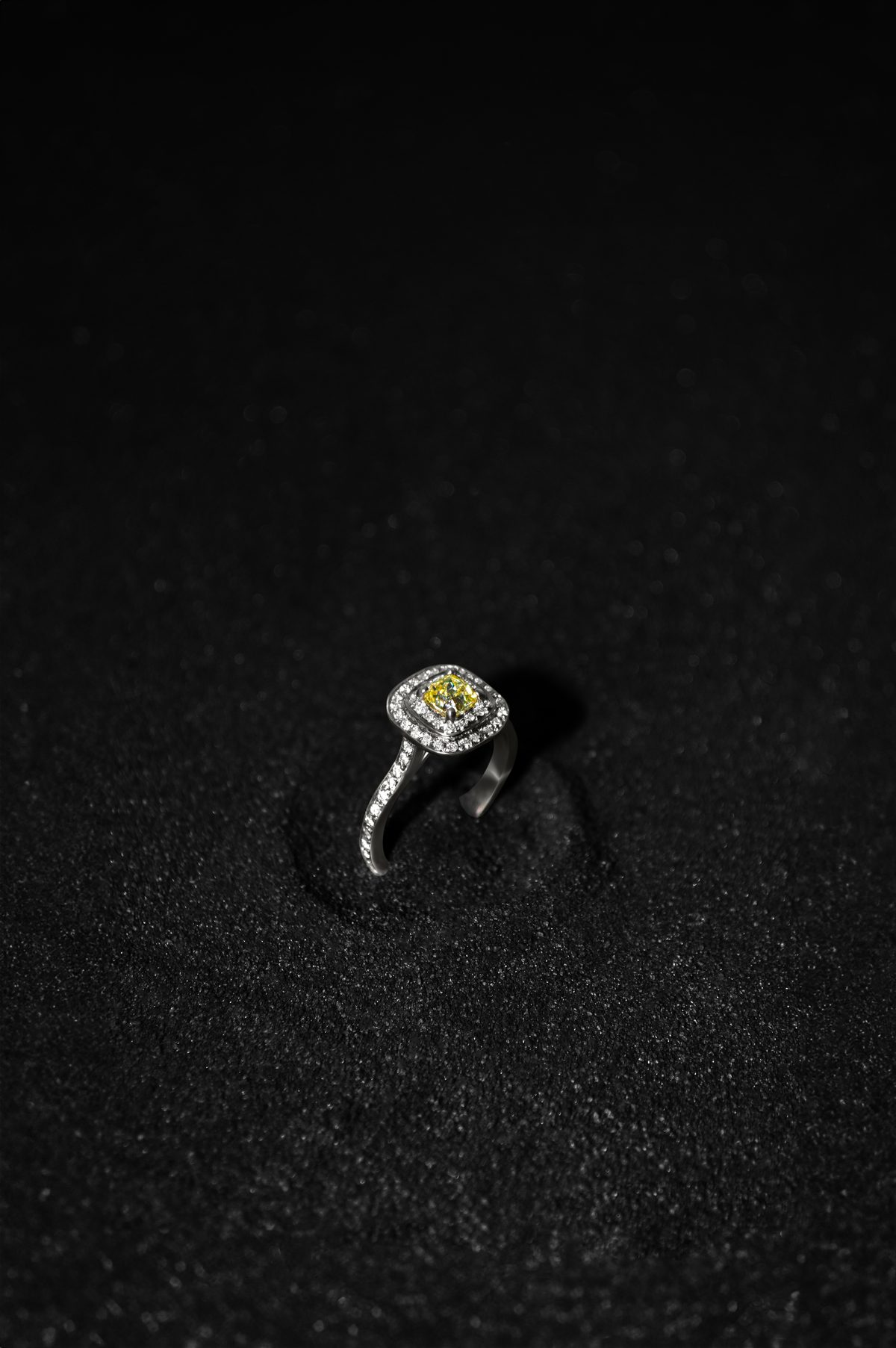 Anillo YS.02 con diamante amarillo y doble halo de diamantes blancos en oro blanco 14k, sobre arena negra